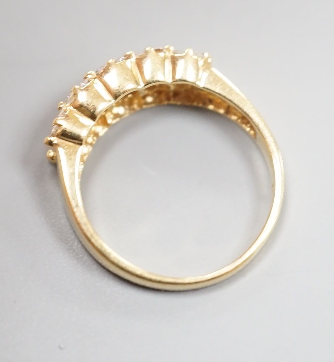 A modern 18ct gold and three row baguette cut diamond and diamond chip set half hoop ring, size M, gross weight 4 grams.